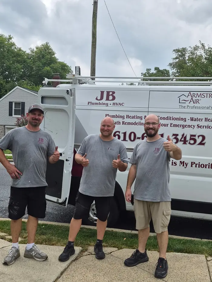 Three JB Plumbing HVAC technicians giving a thumbs up in front of a branded company van