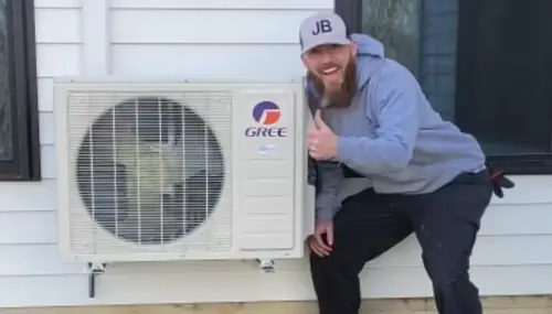 JB Plumbing HVAC technician installing a ductless mini-split condenser