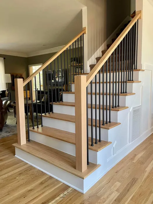 Basement staircase with white wood handrail, finished by JB Plumbing HVAC